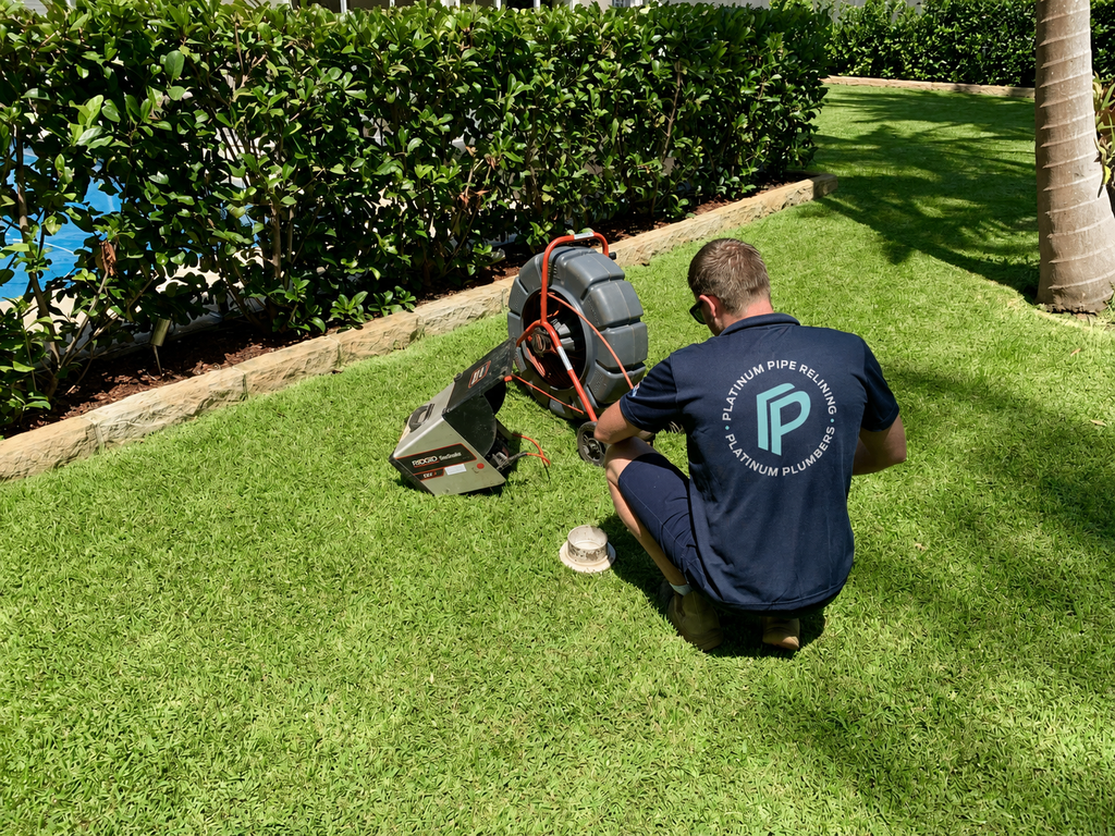 Plumber inspecting stormwater drainage and residential plumbing during a spring home maintenance check in Sydney.